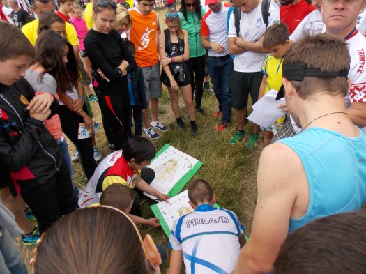 Miika Kirmula, the winner of the men's A-final, drawing his route out on the map as the crowd looks on